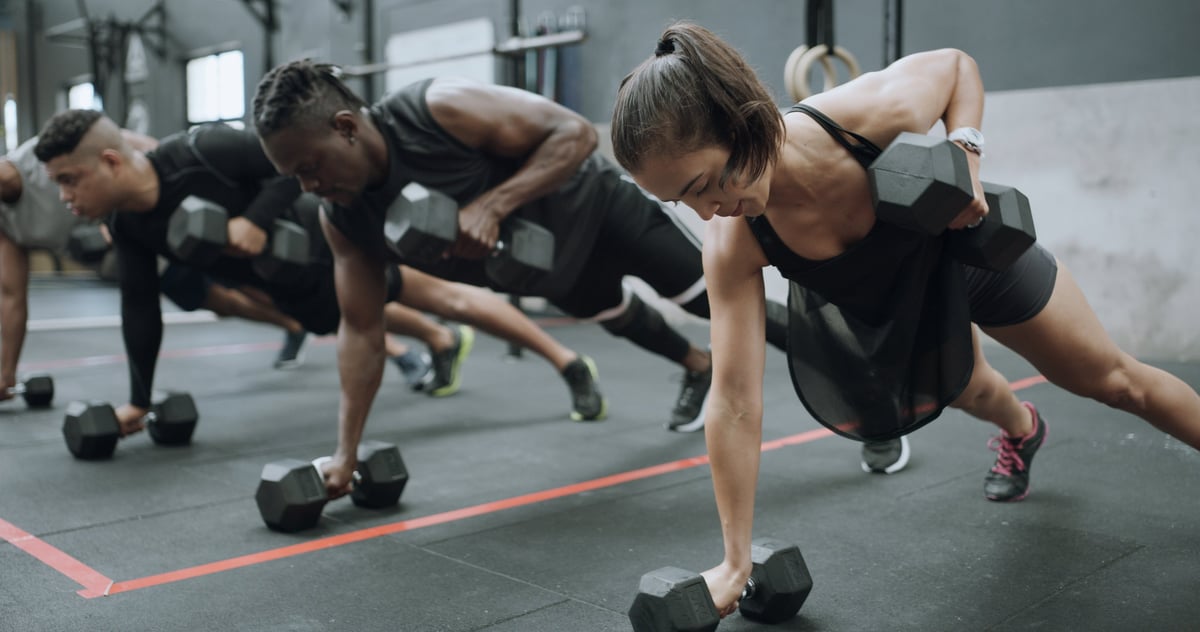 Dumbbells, exercise and row with people in gym together for class, course or workout routine. Fitness, power and weight training with athlete group on floor in health club for challenge or strength